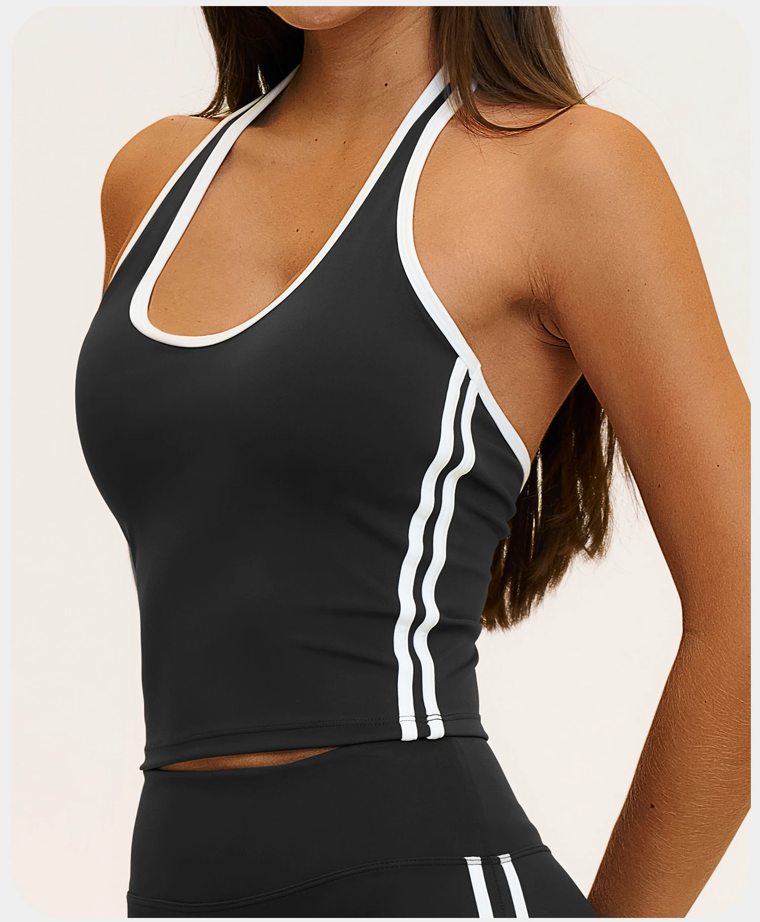White contrast binding along the neckline and side of a black activewear top.