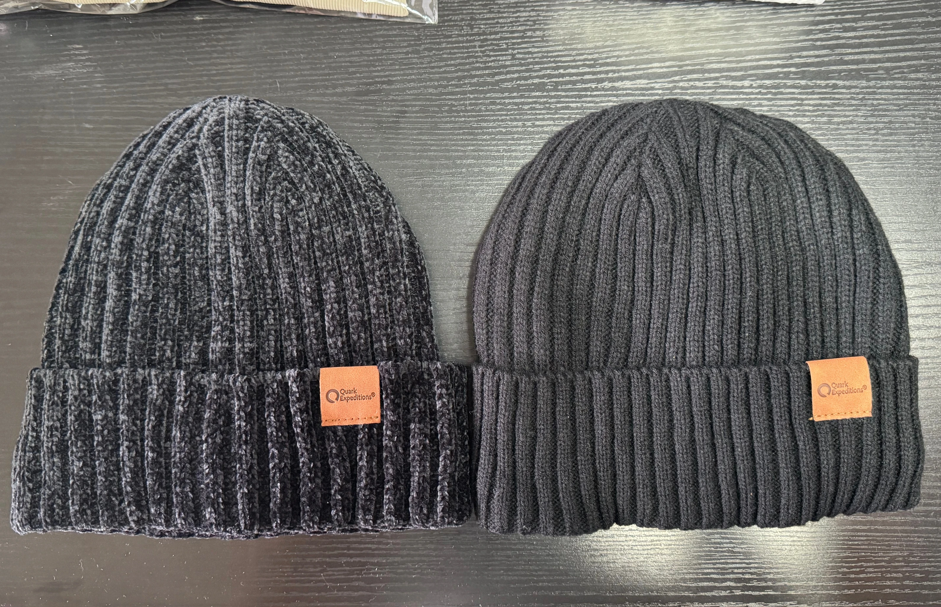 Dark gray rib-knit beanie cuff with a stitched rectangular label.