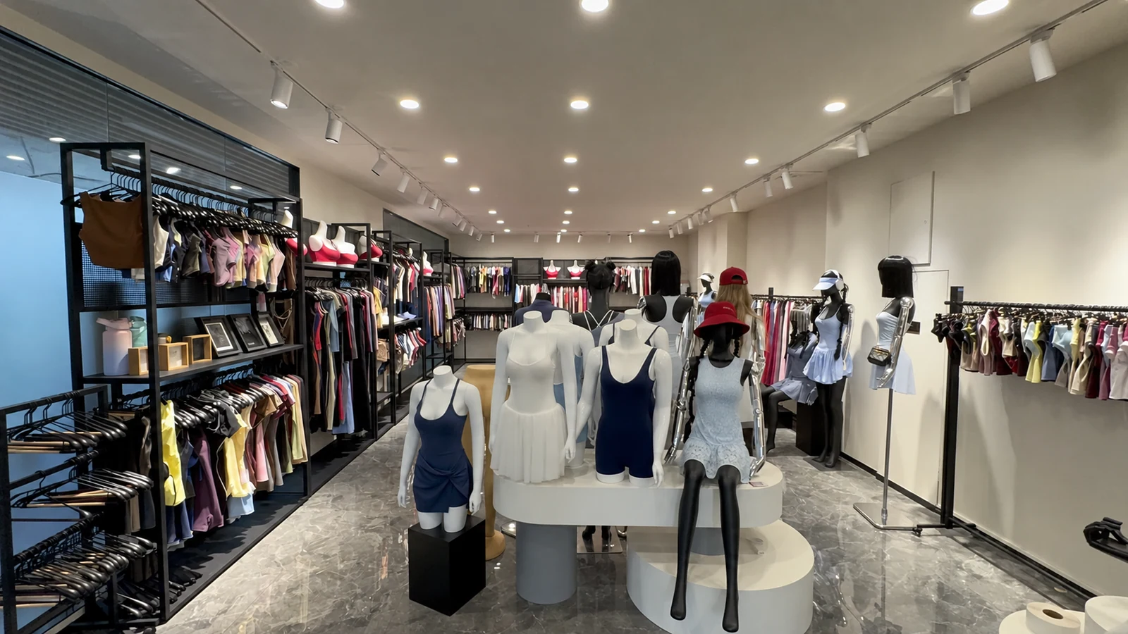 Apparel showroom with sample garments on mannequins and surrounding display racks.