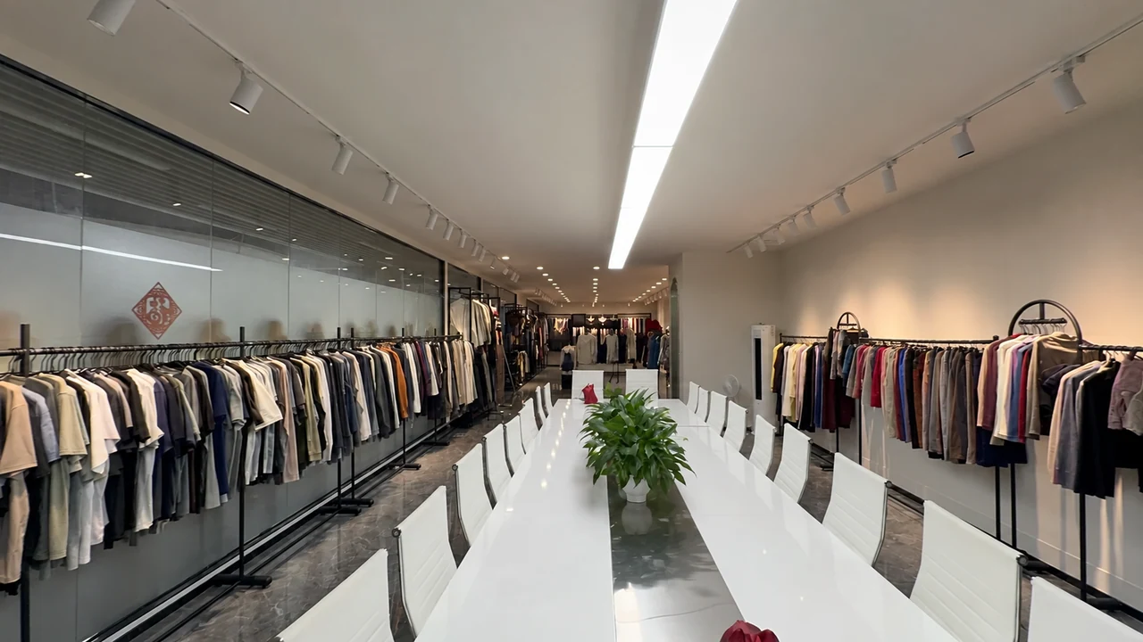 A meeting table surrounded by apparel samples in a showroom.