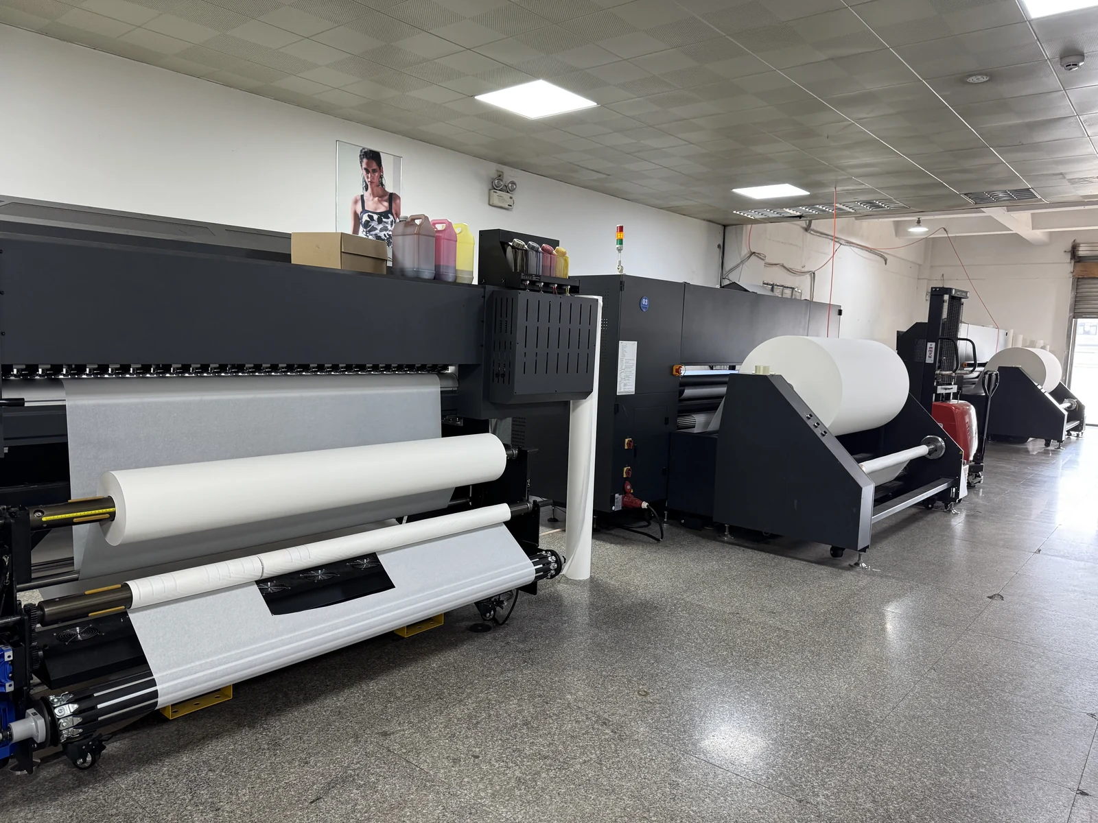 Printing equipment and rolls of material on the production floor.