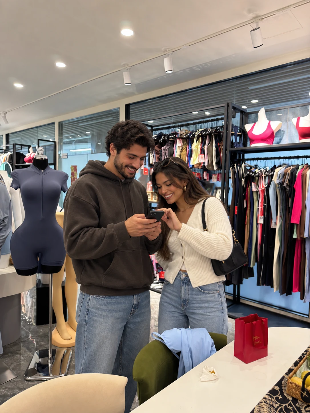 Two people looking at a phone together in the apparel showroom.